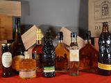 many bottles of alcohol sitting on a table next to boxes