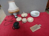 une table sur laquelle se trouvent une lampe, des assiettes, des tasses et des assiettes