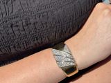 a woman that is wearing a bracelet with a diamond on it