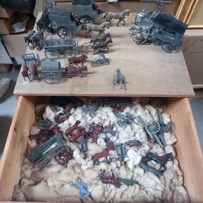 une boîte en bois remplie de figurines militaires posée sur une table