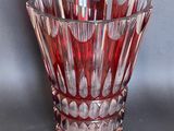 a red glass vase that is sitting on a table
