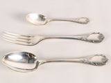 three silver spoons and a fork on a white surface