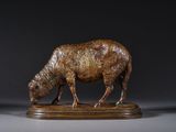 statue d'un mouton posée sur un socle en bois, sur fond noir