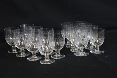 six verres à vin transparents sont alignés sur une surface noire
