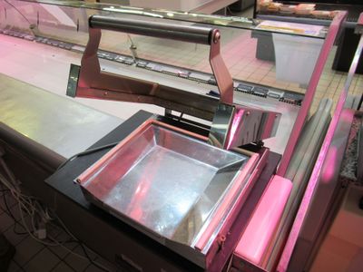 a glass display case in a deli with a pink light