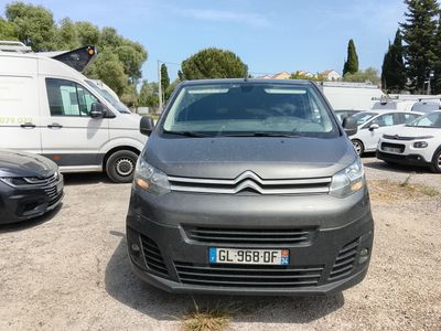 La petite camionnette est garée sur le parking, à côté d'autres voitures.