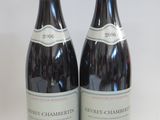 two bottles of wine sitting next to each other on a table