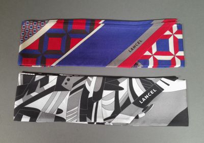two ties with different designs on them sitting on a table