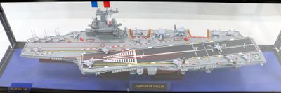 a model of an aircraft carrier on display in a glass case