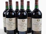 quatre bouteilles de vin rouge sont alignées sur une surface blanche