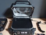 a grill with a grilling pan and other items on a table