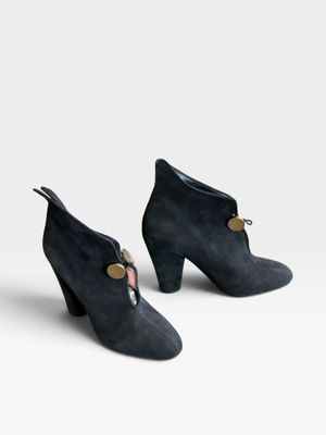 une paire de bottines en daim noir ornées de boutons dorés