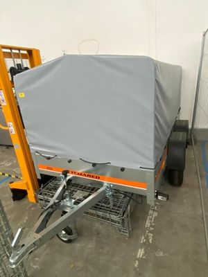 un petit chariot recouvert d'une bâche dans un entrepôt