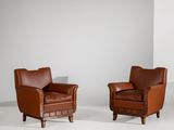 deux fauteuils en cuir marron dans une pièce blanche aux murs blancs