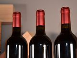 three bottles of red wine sitting on a table
