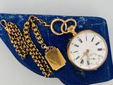 une montre à gousset en or avec une chaîne autour d'elle