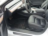 the interior of a car with the door open and the driver ' s seat down