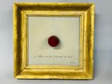 tableau représentant une pomme rouge dans un cadre doré sur fond blanc