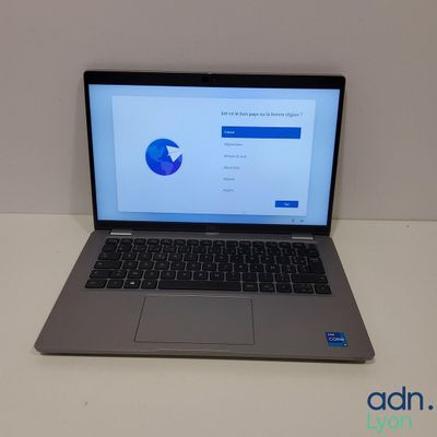 un ordinateur portable ouvert posé sur une table blanche