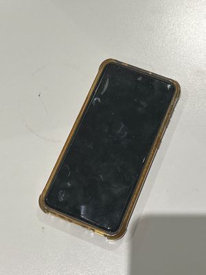 un téléphone portable cassé posé sur une table blanche