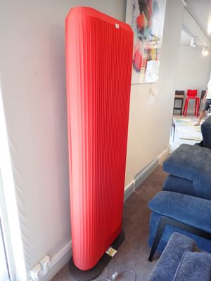 une grande lampe rouge qui se trouve à côté d'une chaise bleue