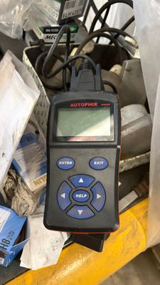 une télécommande posée au sommet d'une pile d'objets divers