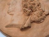 a close up of a bronze medal with a woman ' s face