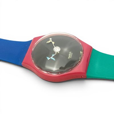 a colorful wrist watch on a white surface with a white background