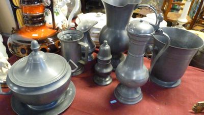 de nombreux vases en argent posés sur une table rouge