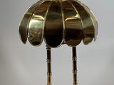 a brass table lamp with a brass shade on top of it