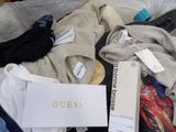 a suitcase full of clothes and a box with a tag on it