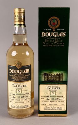 une bouteille et un carton de whisky écossais Douglas posés sur une table