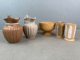Plusieurs vases et tasses sont alignés sur une table