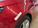 a close up of a red car with a sticker on it