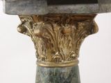 a close up of a green marble pedestal with a gold base