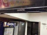 a television mounted on the wall above a kitchen counter