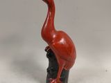 a red bird that is sitting on top of a black vase