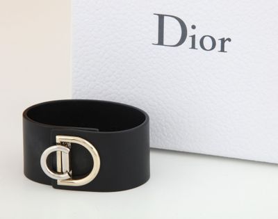 a close up of a black leather bracelet with a gold buckle
