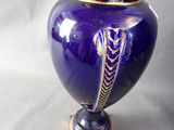 a purple vase with a gold decoration on it