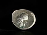a close up of a silver coin with a face on it