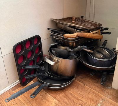 de nombreuses casseroles et poêles qui traînent par terre dans la cuisine