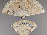 a white fan hanging on the wall next to a mirror