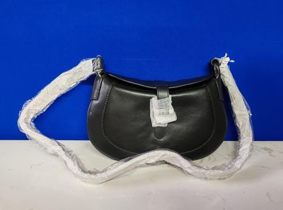 un sac à main en cuir noir muni d'une anse en dentelle blanche