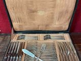 un coffret en bois contenant de l'argenterie sur une table