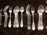 un grand nombre de fourchettes et de cuillères posées sur une table