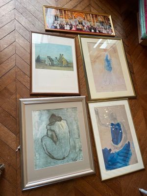 four framed pictures on the floor of a room