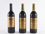 three bottles of wine sitting next to each other on a white surface