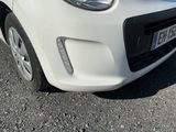 a small white car parked on the side of the road