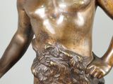 bronze statue of a man holding a hammer and a bowl