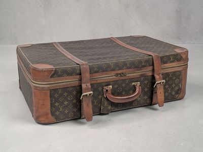 une valise marron posée sur une surface blanche